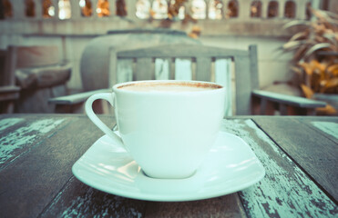 Front view of hot coffee cup on wooden table at the cafe background.
