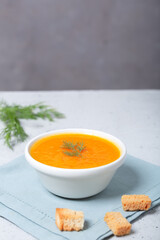 Pumpkin soup in a bowl with fresh dill herb