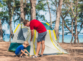 Camping people outdoor lifestyle tourists put up set up green grey camp site summer forest near...