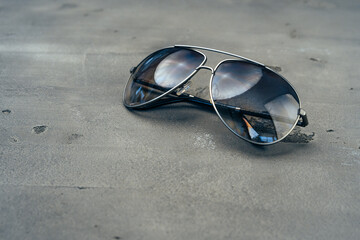 Fototapeta na wymiar New dark aviator glasses on grey concrete background