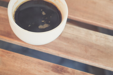 A Cup of hot latte art coffee on wooden table.