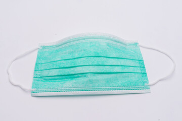 Surgical mask with rubber ear straps. Typical 3-ply surgical mask to cover the mouth and nose. Procedure mask from bacteria. Protection concept. Mask on white back ground,covid