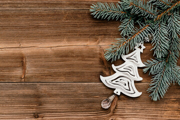 Christmas frame made of blue fir tree branches and silver toy Christmas tree on the dark wooden rustic background.Christmas background.Copy space for text, top view, flat lay