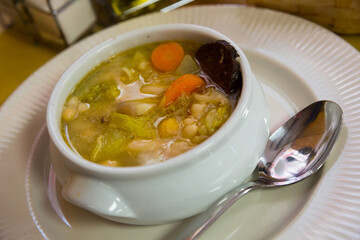 Bean's catalan soup with boiled carrots and potatoes , served with black sausage in bowl