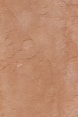 Abstract background of an exterior reddish brown adobe style textured wall surface