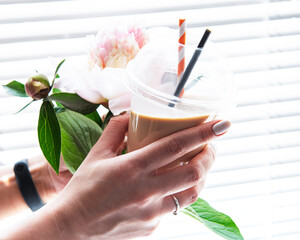 Delicious cold coffee cocktail with milk in female hands