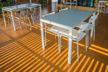 The cozy interior design of the cafe with table and chair with sunlight in the morning. The modern casual coffee shop or restaurant background.