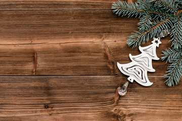 Christmas frame made of blue fir tree branches and silver toy Christmas tree on the dark wooden rustic background.Christmas background.Copy space for text, top view, flat lay