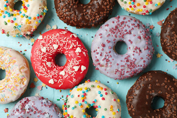 Tasty donuts on blue background, top view