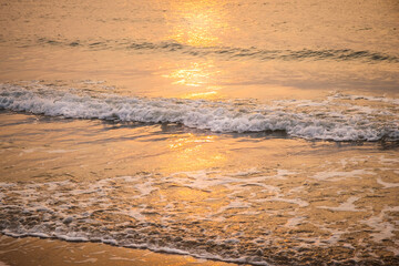Beautiful golden sunset over the horizon on the beach, Thailand. Tropical colorful sunrise from the sea.
