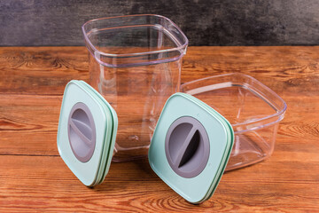 Empty food storage containers with open lids on rustic table