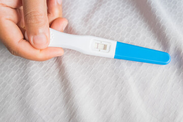 Young woman happy holding after positive pregnancy test.