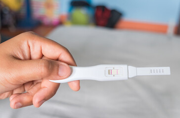 Young woman happy holding after positive pregnancy test.