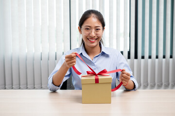 Asian women happy to open surprise box are stunned with excitement, joy and smile on holidays, Christmas, birthday or Valentine's Day concept
