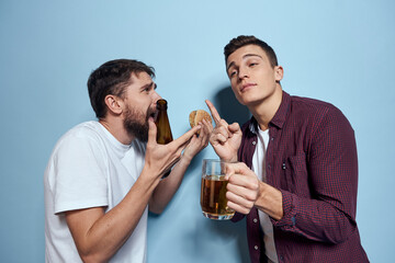 Two cheerful drunk friends drinking beer lifestyle emotions on a blue background