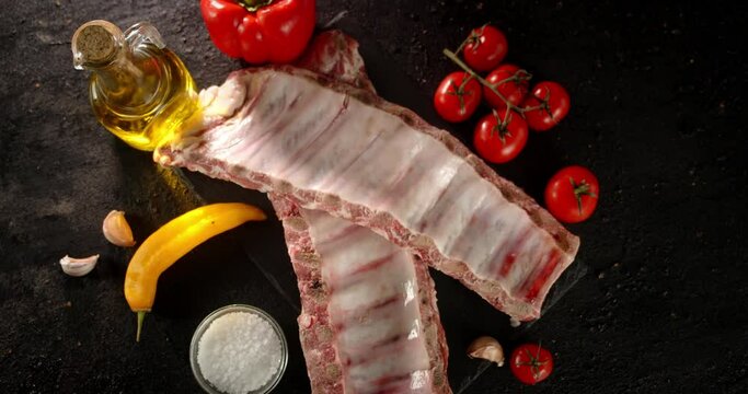 Raw ribs with oil and tomatoes slowly rotate. 