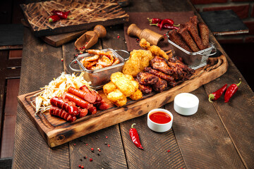 Fried beer snacks on the wooden board with sauces