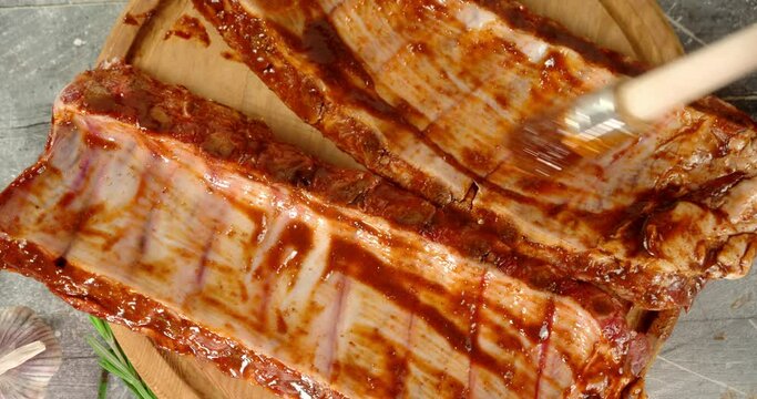 The men's hand marinates in raw rib sauce.