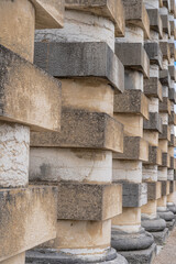 Arc-Et-Senans, France - 08 31 2020: Royal Saltworks of Arc-Et-Senans. Details of alternation of cylindrical and cubic stones on director's house columns