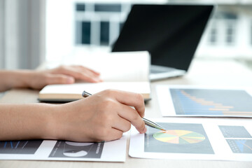 Businesswoman hand holding pen and analysis the chart with laptop at the office for setting challenging business goals And planning to achieve the new target