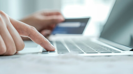Businesswoman hand use laptop and holding credit card to online shopping from home, payment e-commerce, internet banking, spending money for next holidays
