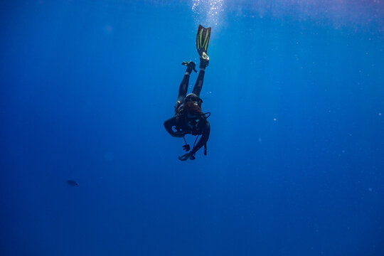 Scuba diver entering water in a vertical position