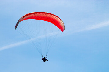parachute paraglider in flight against the background of a clear blue sky
