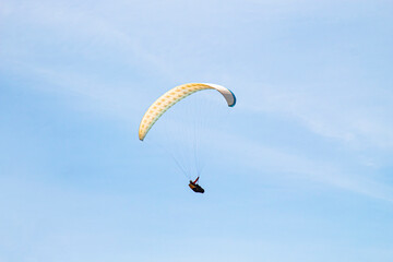 parachute paraglider in flight against the background of a clear blue sky