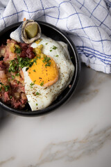 Norddeutscher Hamburger Labskaus mit Rindfleisch Corned Beef, Rote Beete, Kartoffeln, Saure Gurken, Spiegelei und Rollmops in Schale