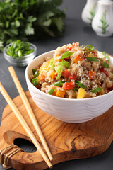 Fried rice with vegetables, garlic, ginger and green onion on dark background. Asian cuisine. Vegetarian food