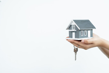 The hand of the real estate agent holding the house model and the keys Loan and home concept