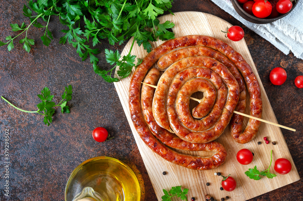 Wall mural Delicious homemade sausages, baked  rings on skewers, with cherry tomatoes. Oktoberfest snack. Summer picnic dish