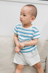 Fototapeta premium A baby boy of one and a half years old is playing in the room