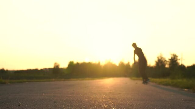 Guy doing tricks on a scooter at sunset