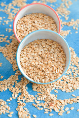 Bowls with raw oatmeal on table