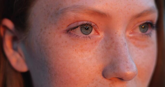 Beautiful woman&rsquo;s eyes opening while looking at Red Sunset, having long nice Eyelashes. Attractive girl with nice Freckles on her Beautiful Face. Red haired woman with Charming Appearance, Sunny Day.