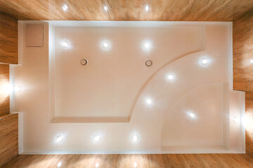 suspended ceiling with halogen spots lamps and drywall construction in empty room in apartment or...