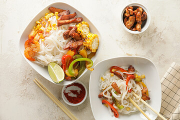 Bowls with tasty rice noodles on table