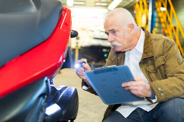 senior worker inspecting car after accident