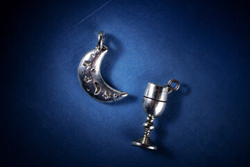 The Moon and the chalice, symbols of a Wiccan ritual, a flat lay on a dark blue background