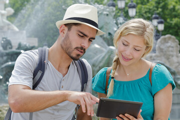 young couple using a digital tablet at seaside town