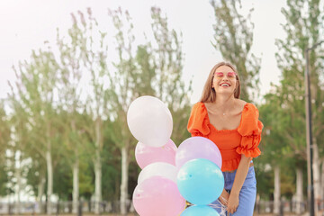 Young woman with balloons outdoors