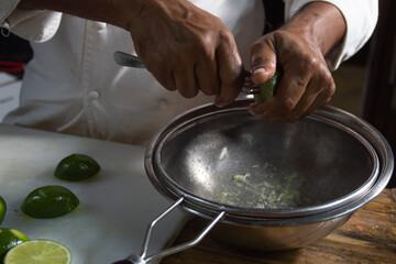 chef dressed in white squeezing lemons