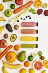 Top view composition of various colorful vegetables and fruits with bottles of healthy detox juices and smoothies isolated over white background