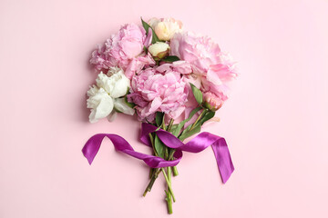 Bouquet of beautiful peonies with ribbon on pink background, flat lay