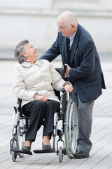 elderly woman in wheelchair turning around to talk to husband