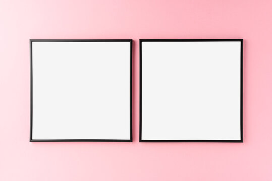 Mockup of two empty photo frames on pink background. Home decoration