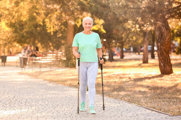 Mature woman with walking poles outdoors