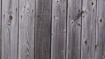 Wooden surface made of old unpainted boards. A fragment of a plank wall or fence.