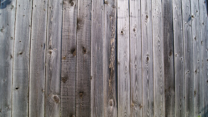 Fototapeta premium Wooden surface made of old unpainted boards. A fragment of a plank wall or fence.